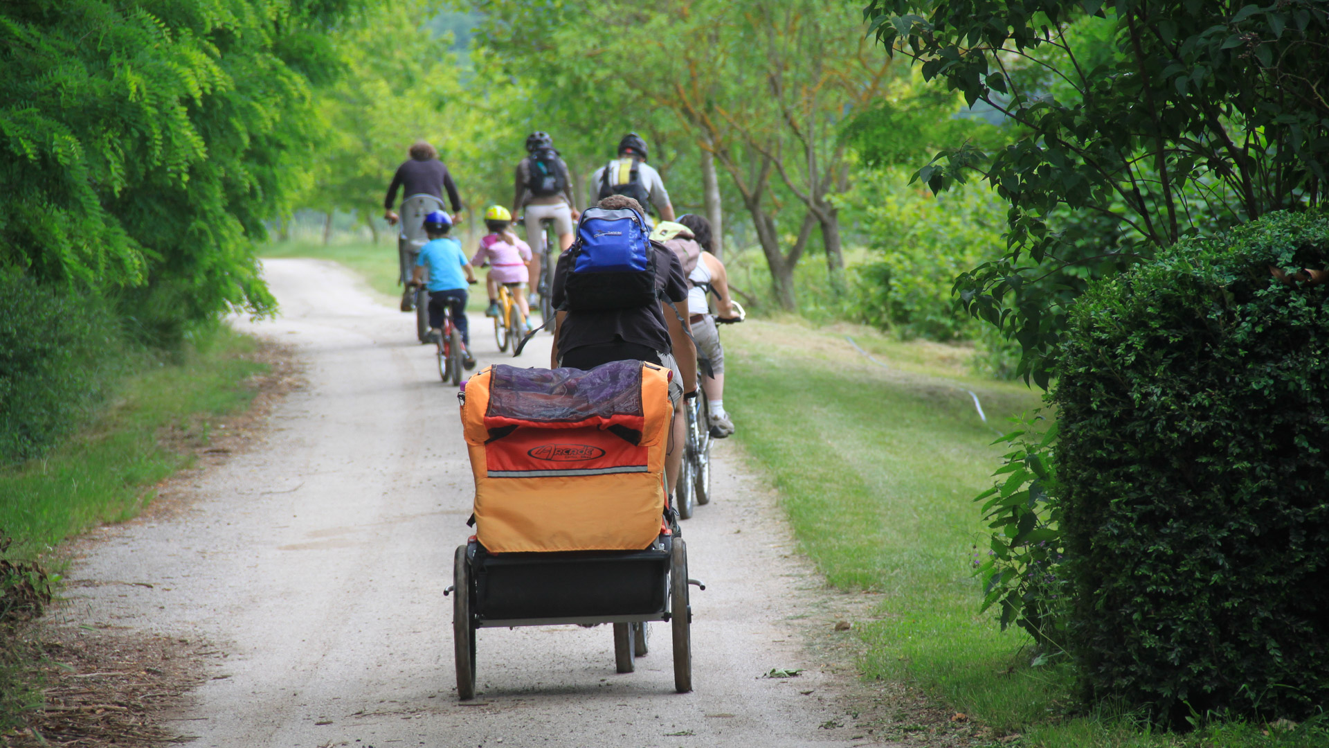 une famille à vélo avec remorque enfants