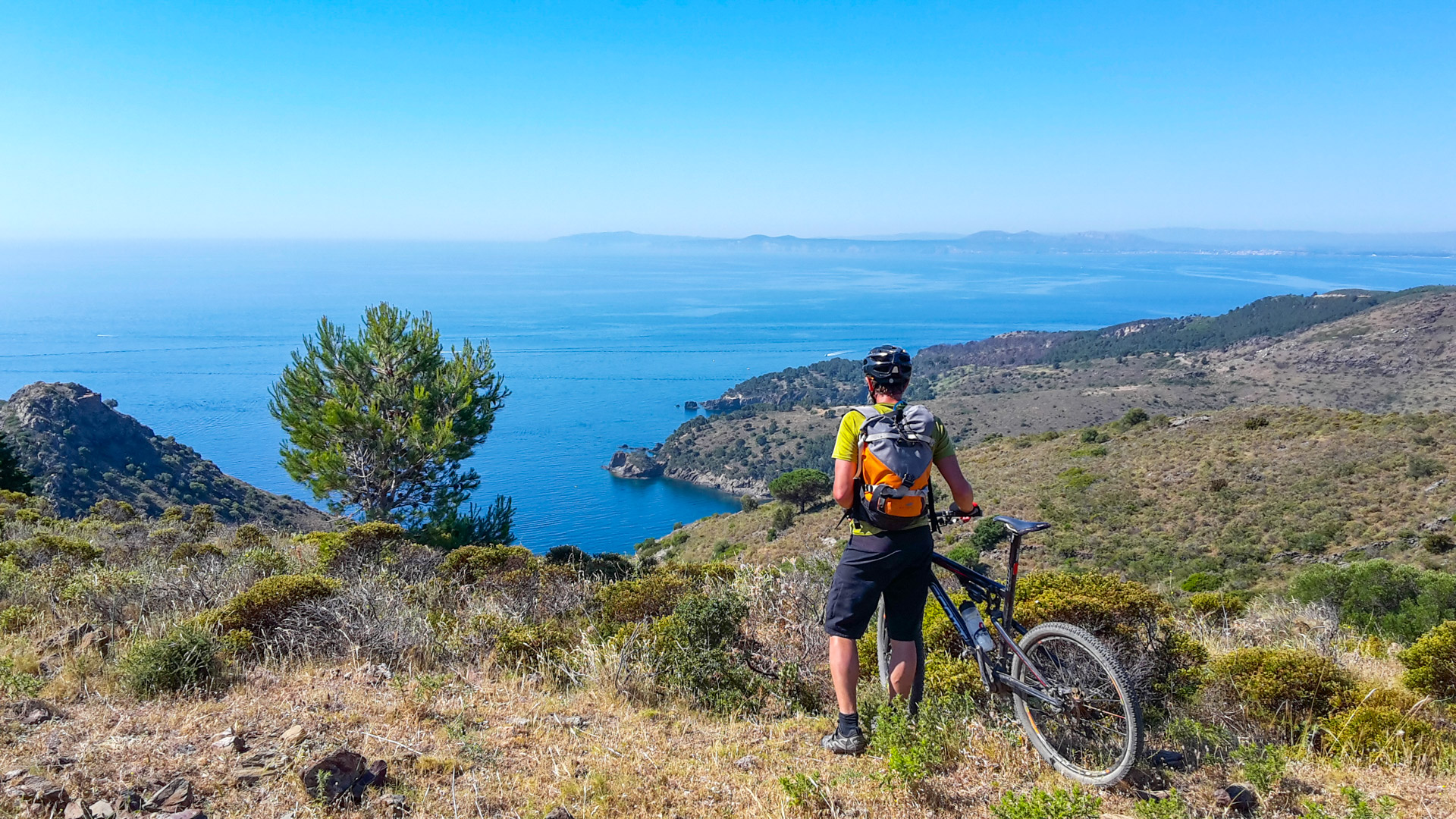 cycliste admire la vue depuis les hauteurs de la Costa Brava