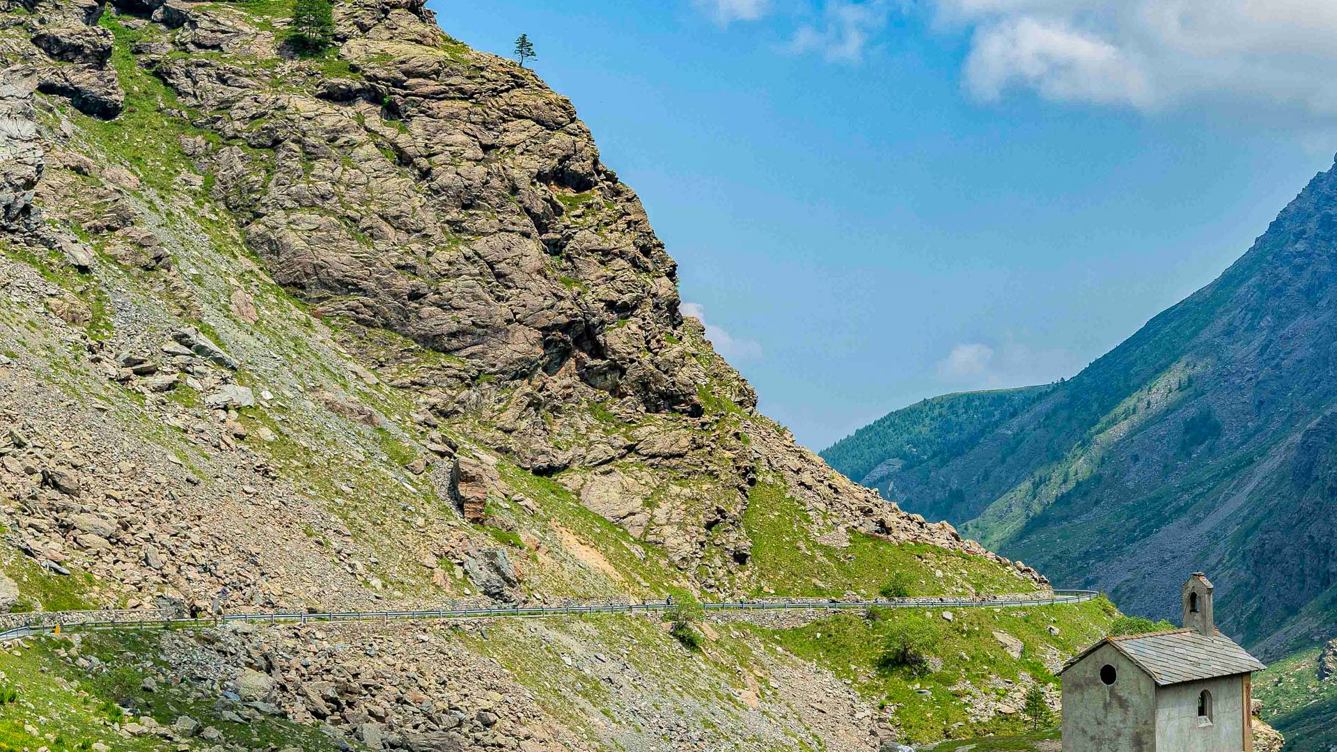 cycliste sur route de montagne dans le piémont Italien à coté dune petite chappelle