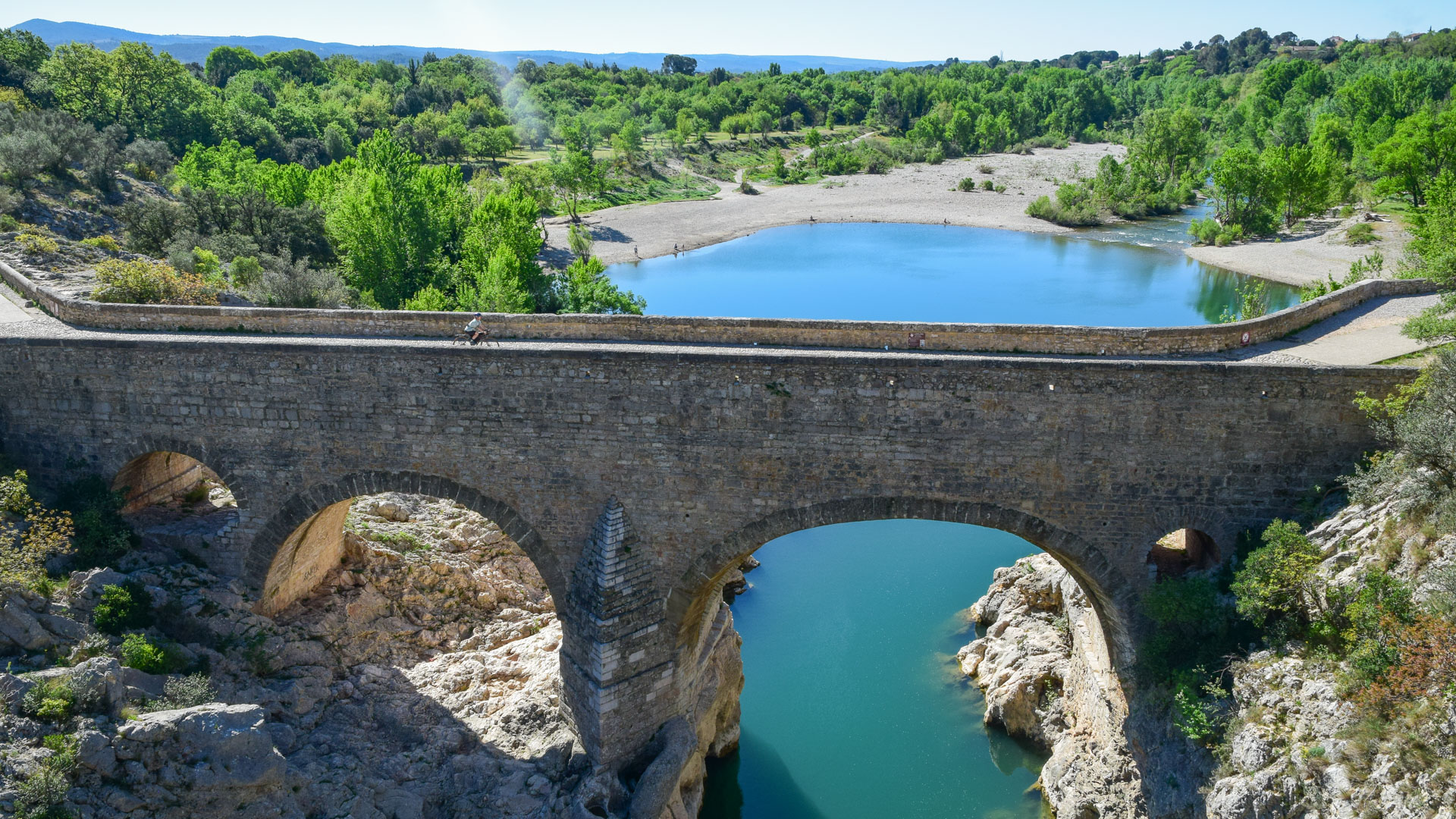 cycliste en gravel roulant sur le pont du Diable à proximité de St Guilhem le Désert