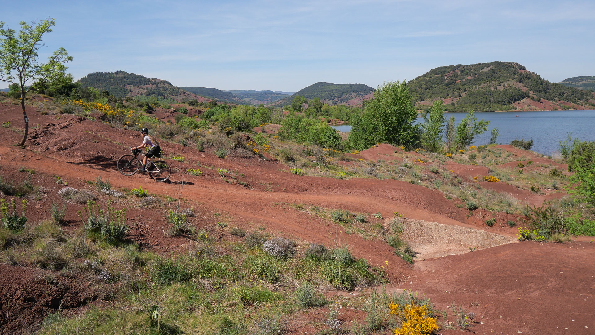 cycliste en gravel sur les rives rouges du lac du Salagou