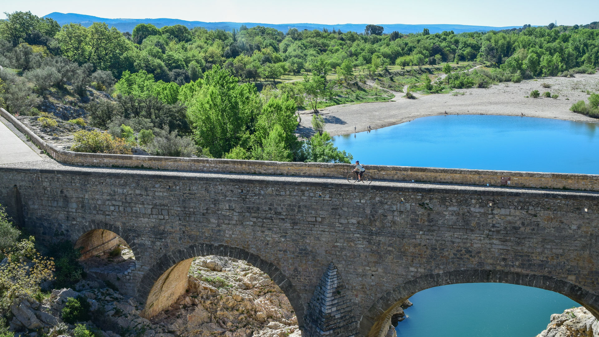 cycliste en gravel sur le pont du Diable près de St Guilhem le Désert
