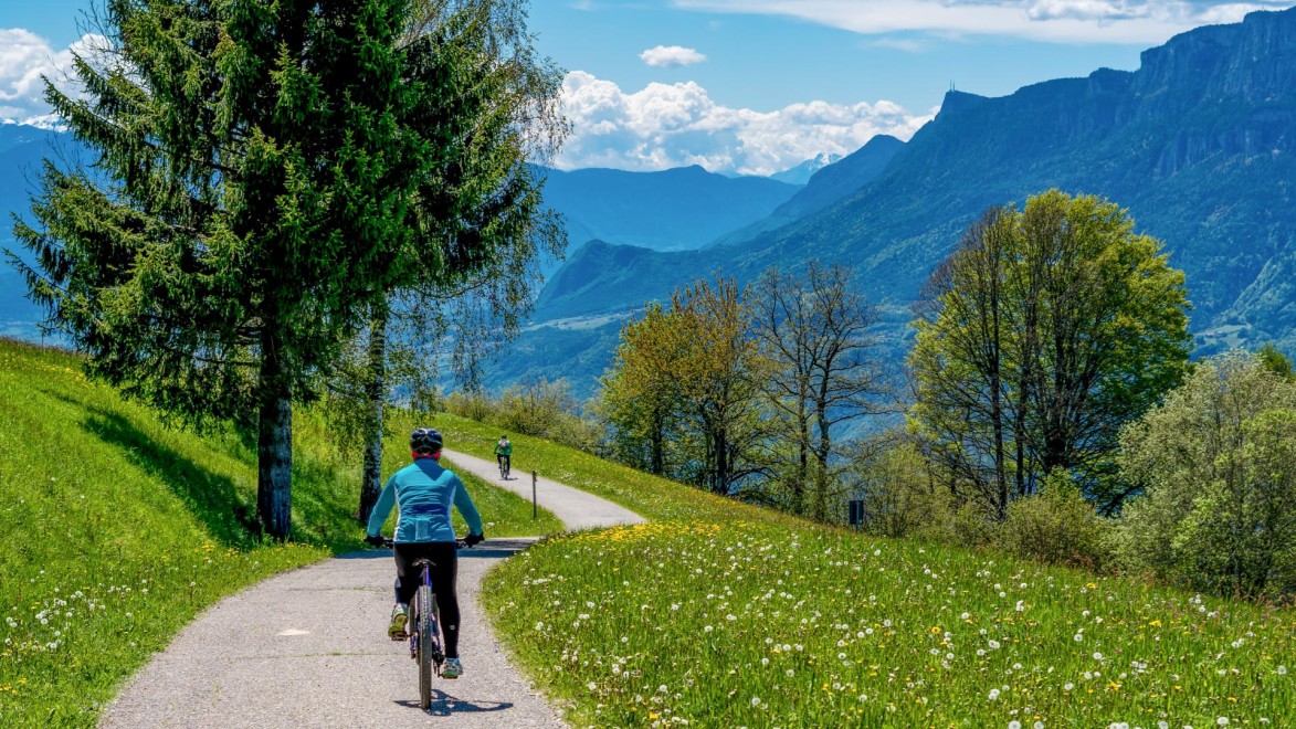 femme à vélo sur une piste cyclable dans les Dolomites