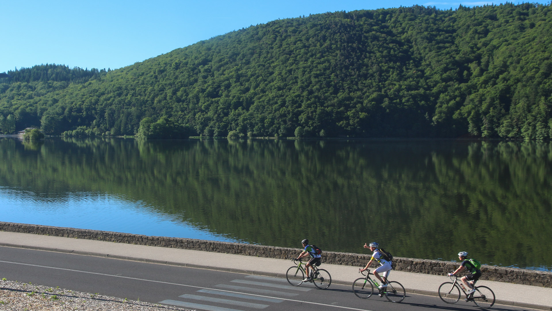 trois cyclistes longent le lac Chambon