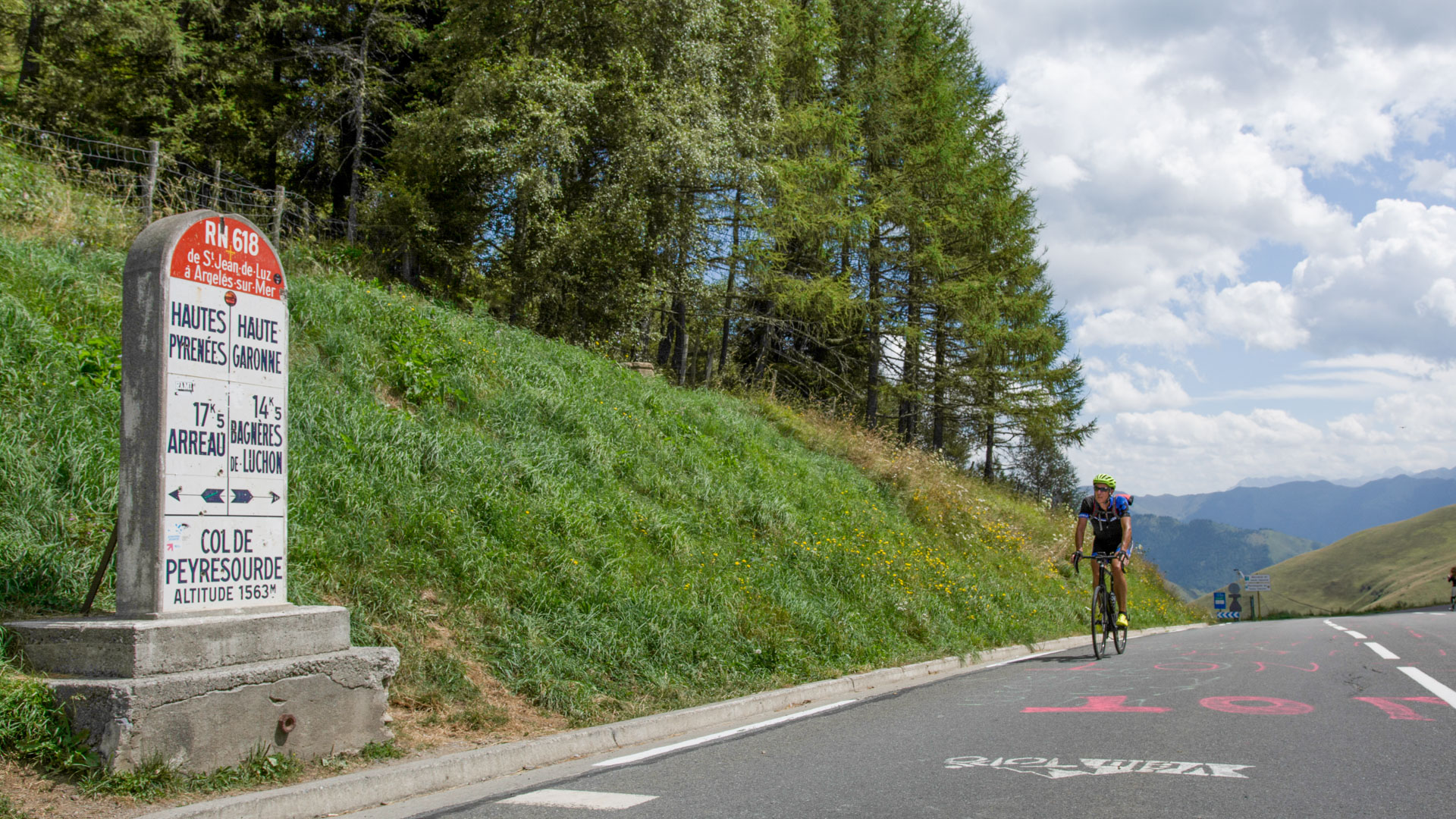cycliste arrivant au col de Peyresourde marquant l'entrée dans le département des Hautes Pyrénées