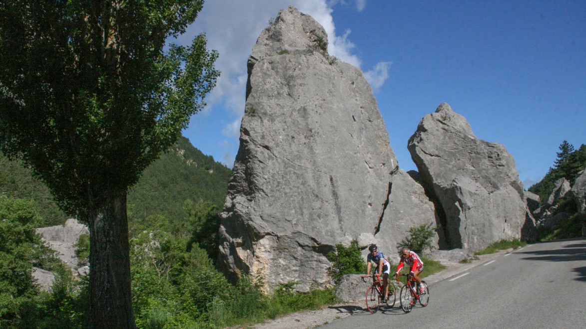 deux cyclistes devant le site naturel du Claps, éboulement de rochers du département de la Drôme