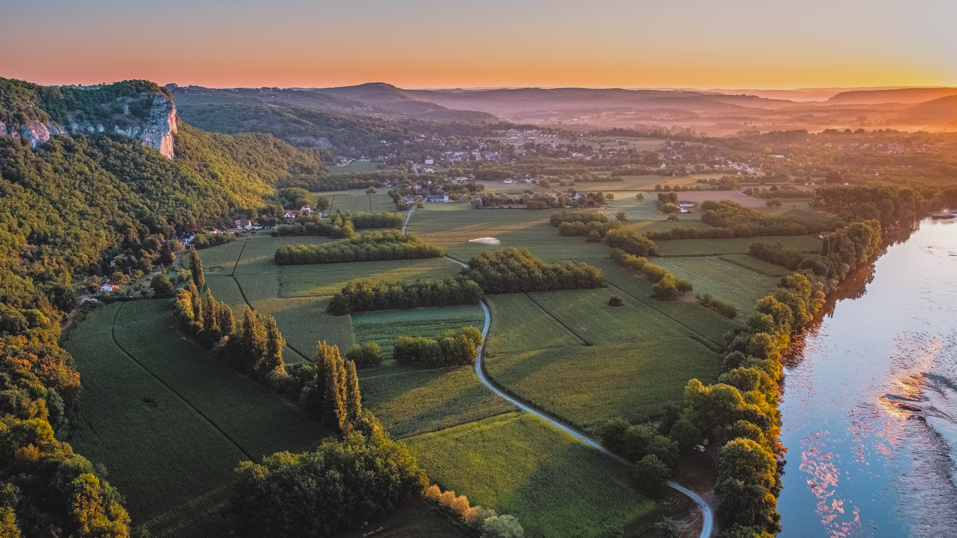 vallée du Lot vue du ciel, avec ses nombreuses vignes et un beau coucher de soleil en arrière plan