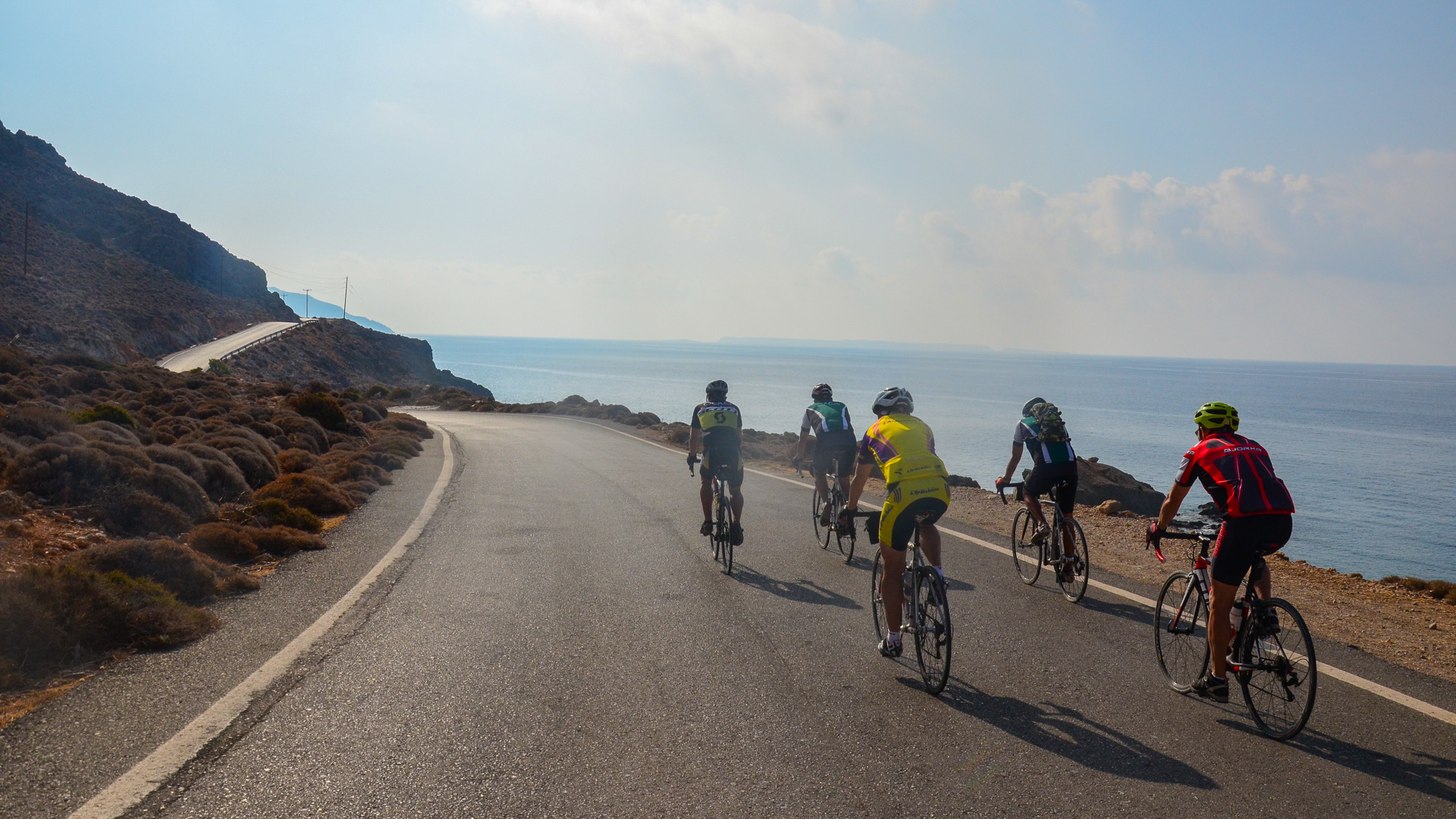 groupe de cyclistes de dos sur une route côtière de l'île