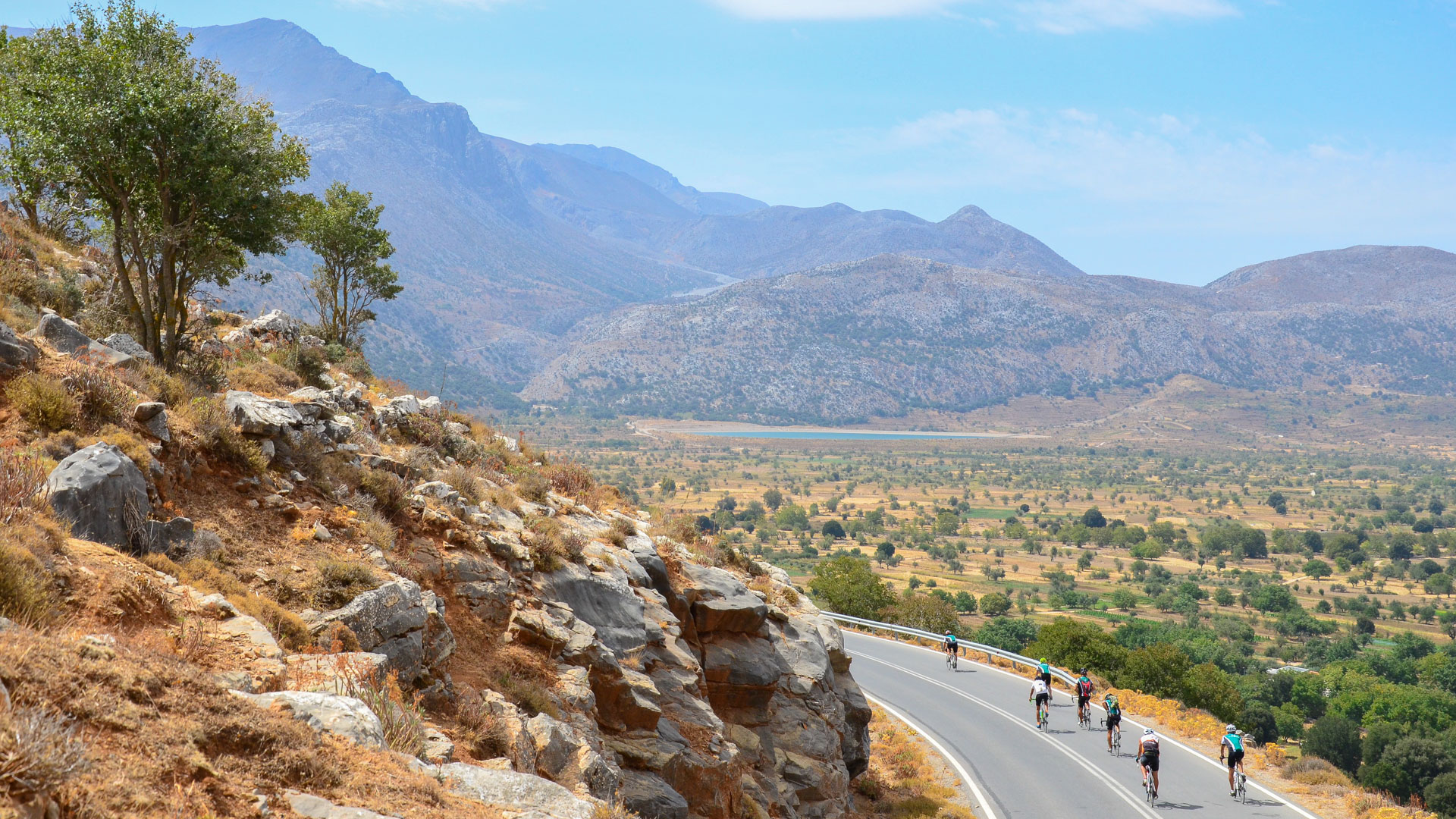 un groupe de cyclistes au milieu d'un plateau sauvage au milieu de l'île, entouré par une chaîne de montagne en arrière plan