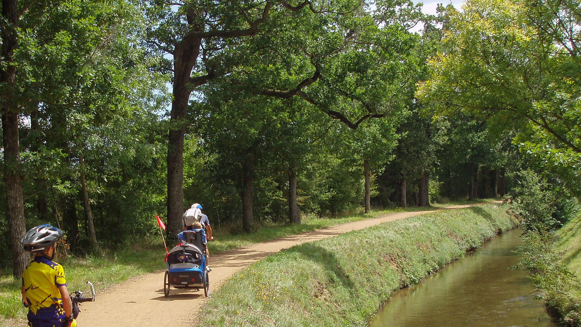 famille et enfants pédalant le long du Canal de la Robine