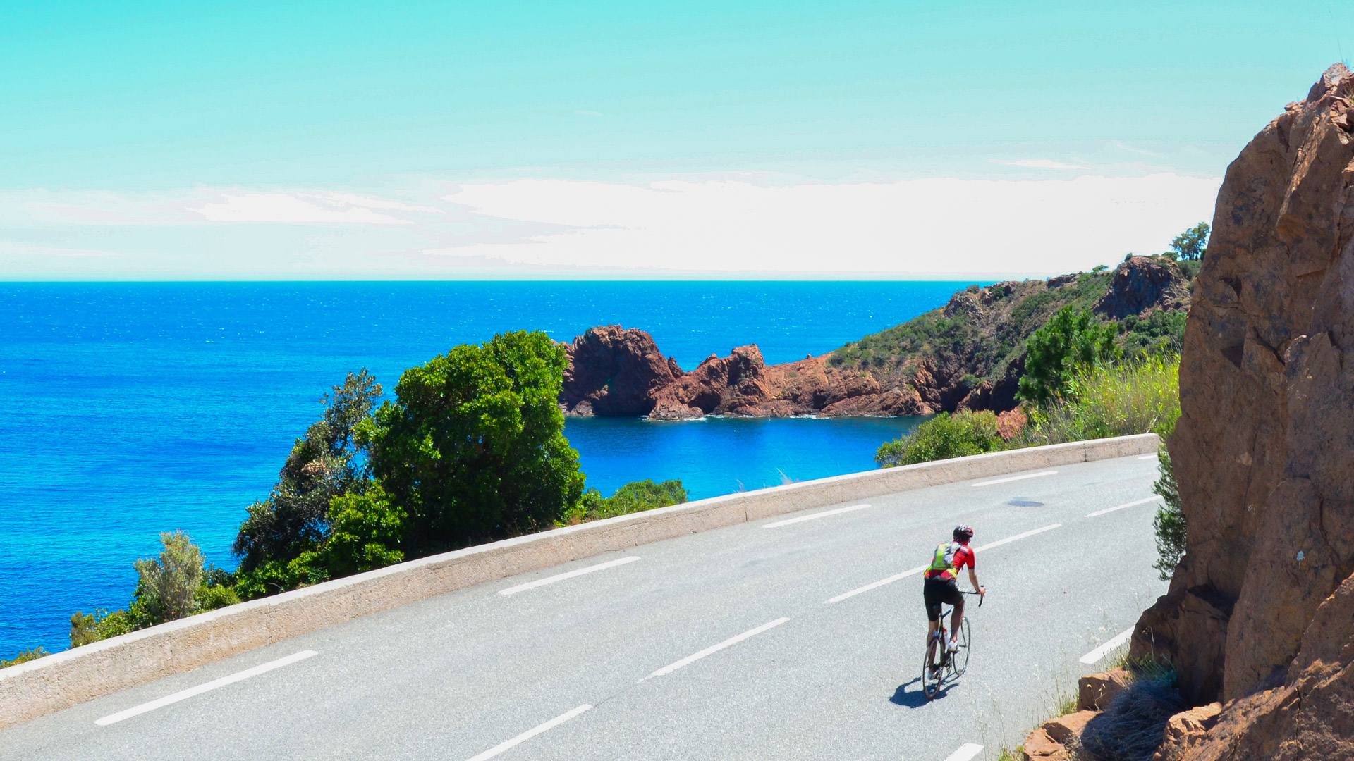 un cycliste sur une route dans le massif de l'Estérel, au bord de la mer Méditerranée