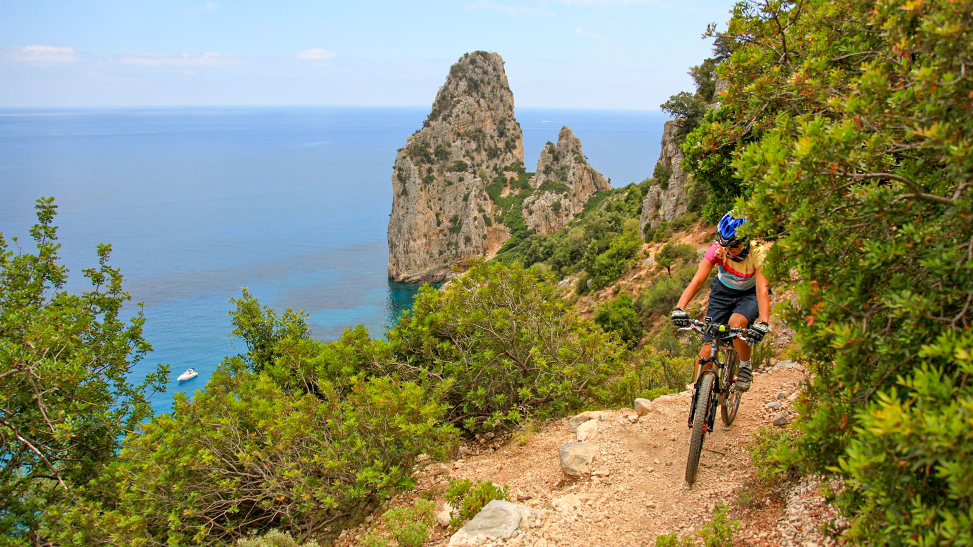 les rives de la Méditerranée avec un VTT qui passe devant une belle aiguille calcaire