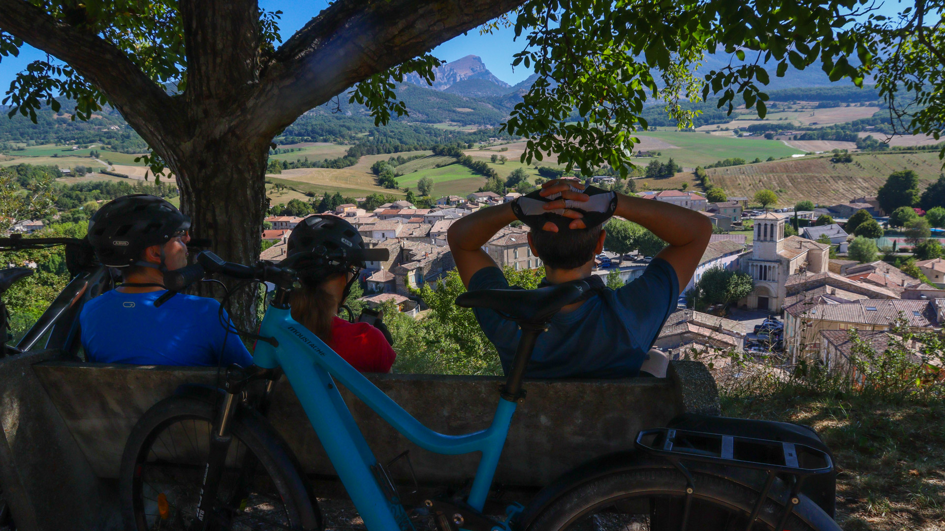 cyclistes en pause devant un village de la Drôme