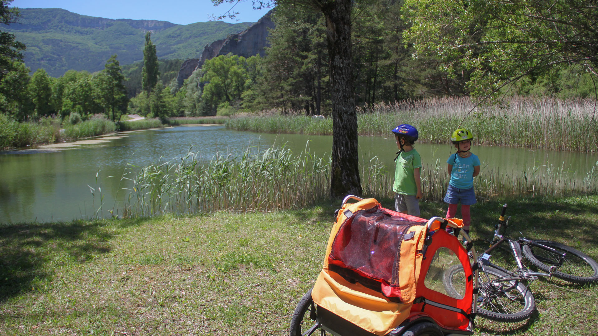 Pause avec les enfants et la remorque vélo bord d'un lac