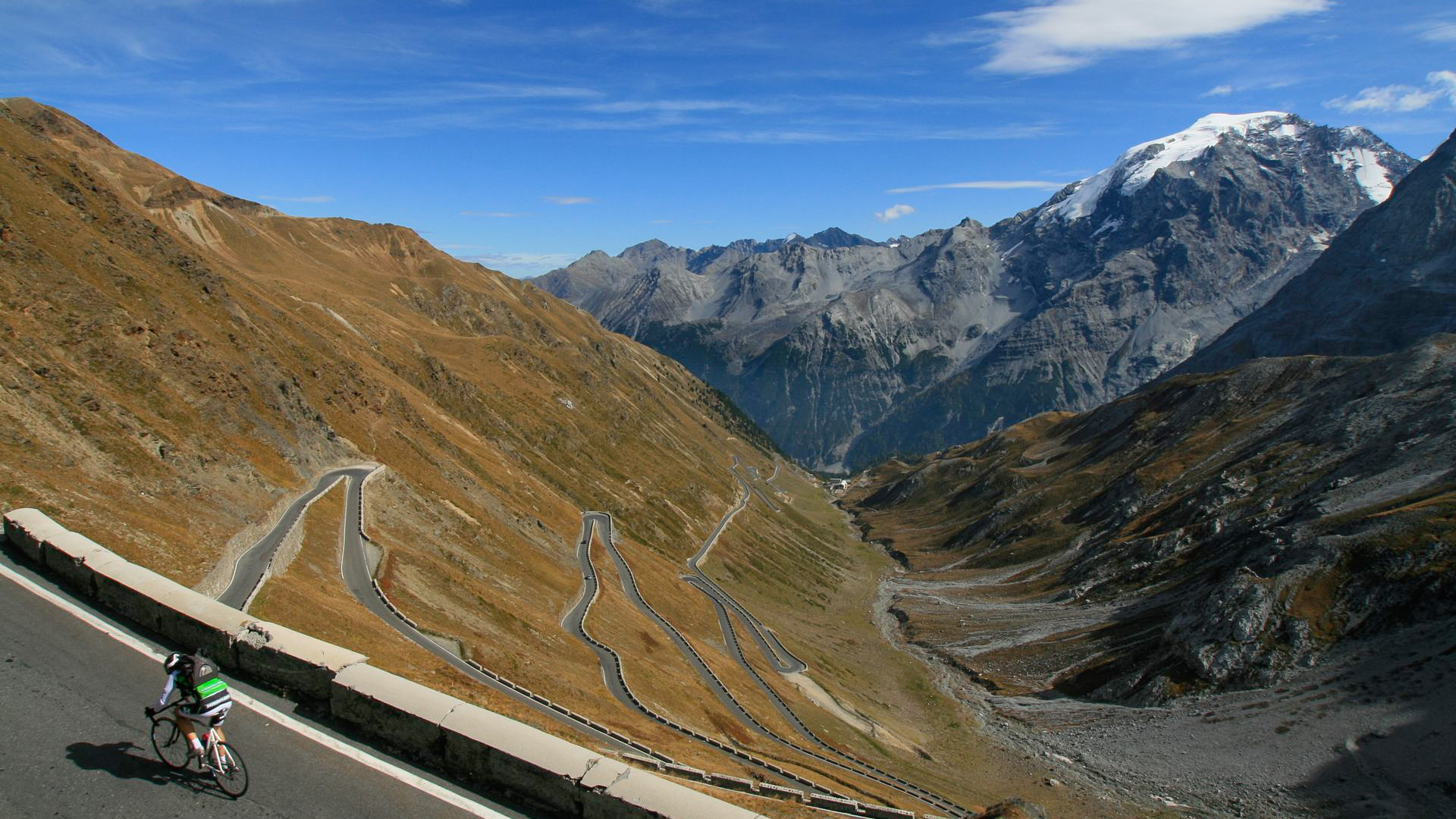 vue plongeante sur le col du Stelvio et ses nombreux lacets, avec le glacier de l'Ortles en toile de fond