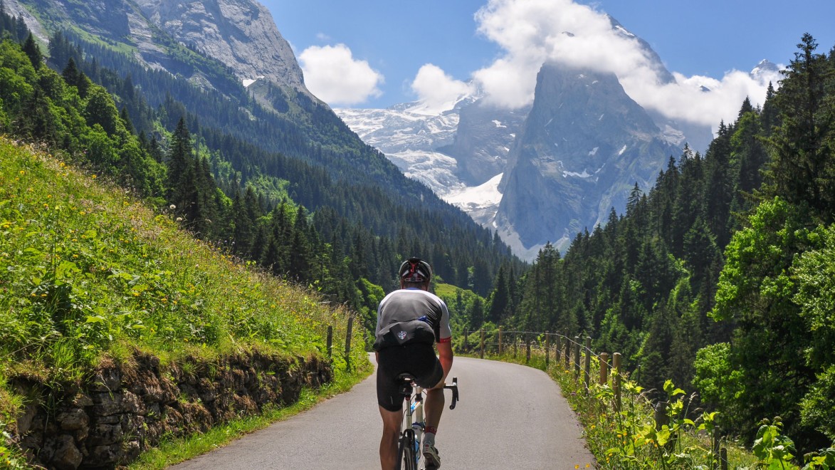 cycliste dans les alpes suisses face à un sommet enneigé de l'Oberland