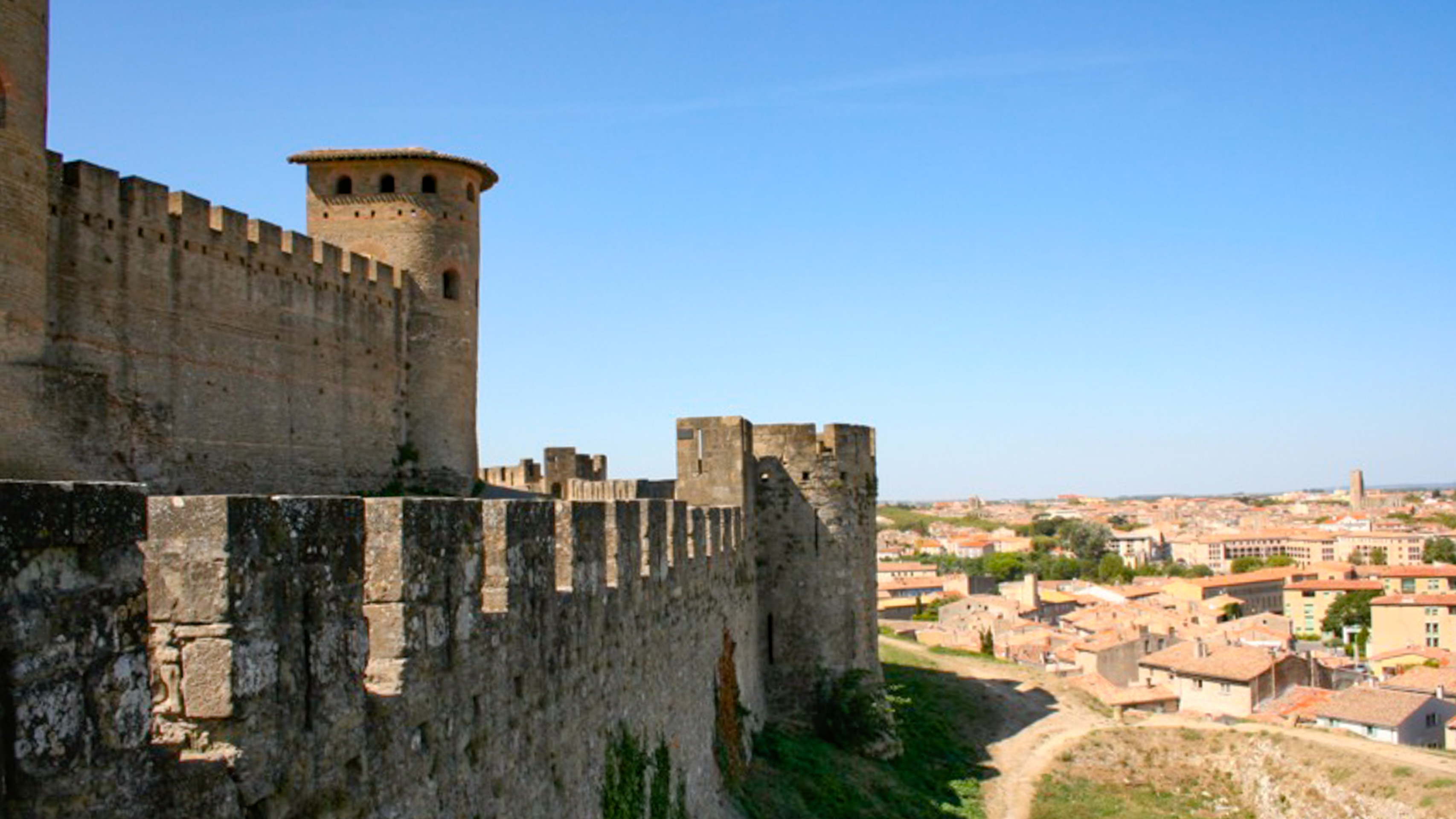 vue sur les remparts de la cité médiévale de Carcassonne, avec la ville en arrière plan