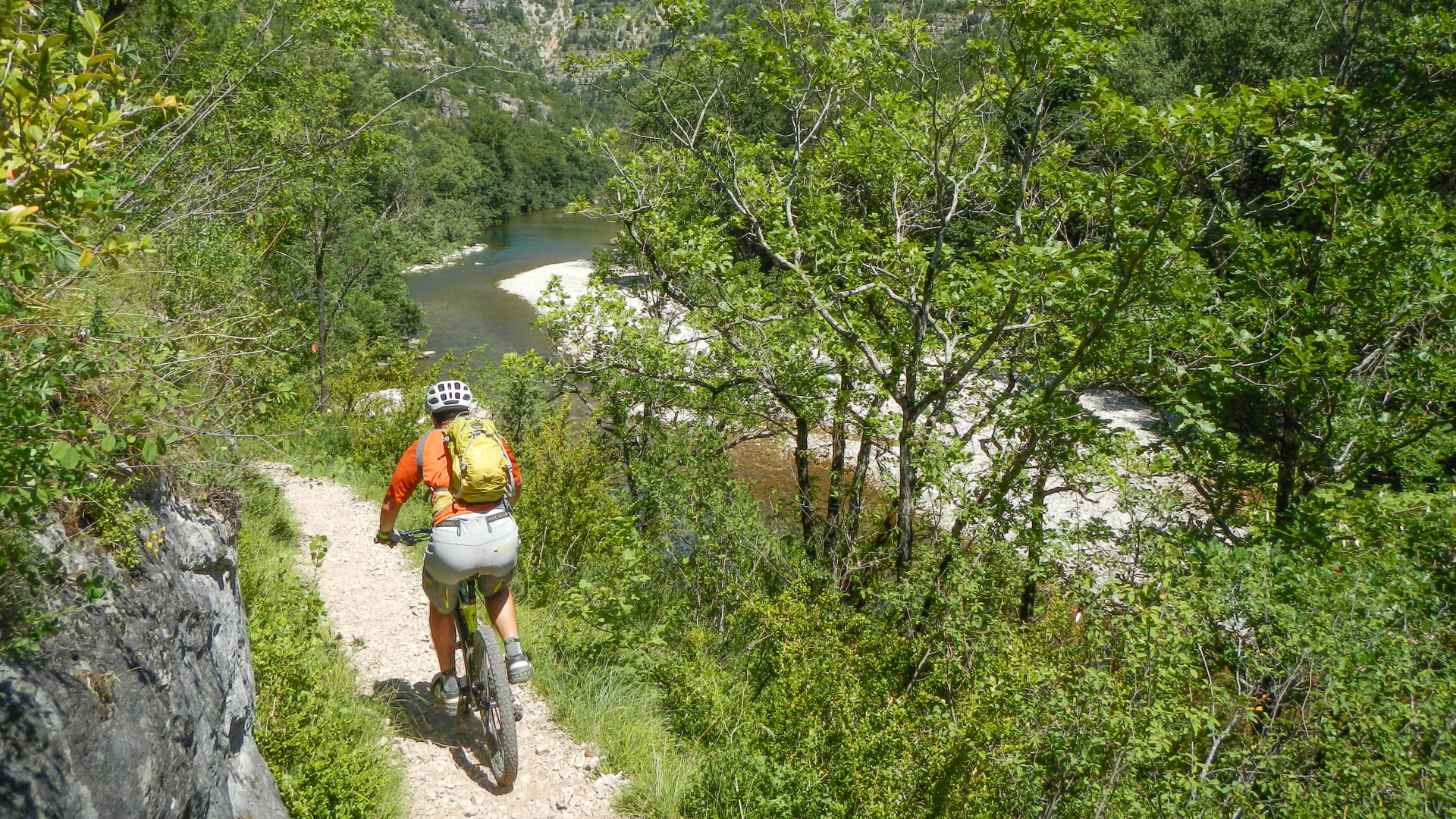 Homme à VTT sur un sentier qui suit le lit de la Dourbie