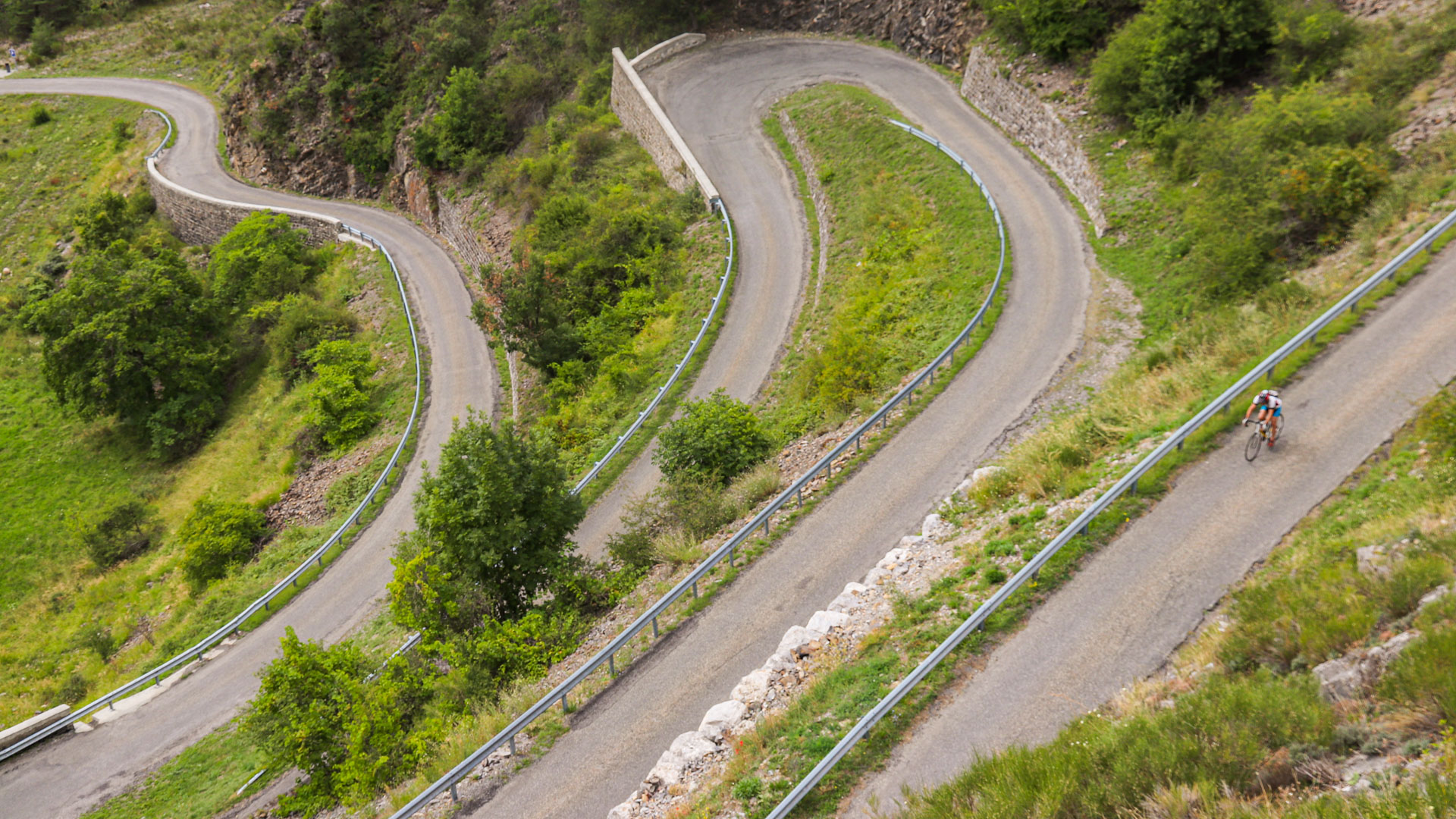 un cycliste qui descend un lacet du col des Sagnes