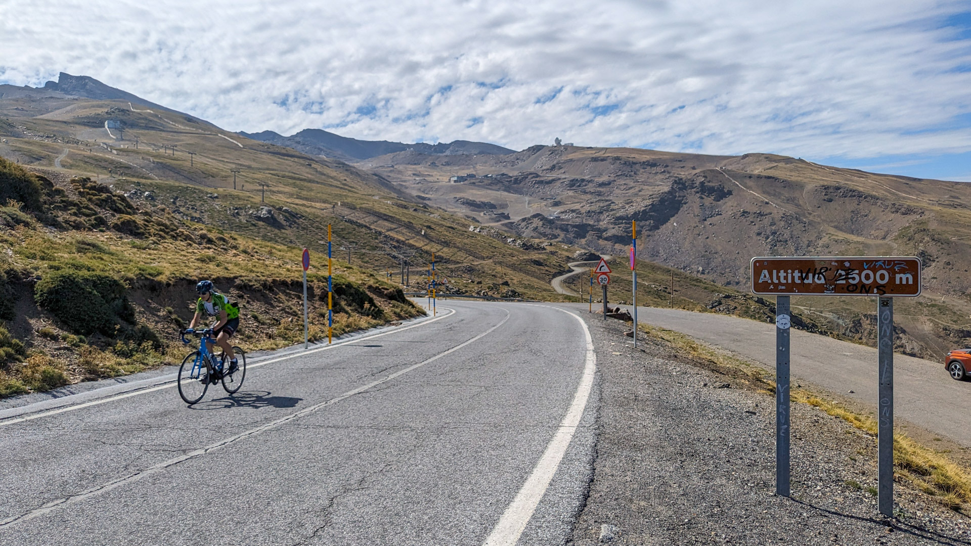 cycliste en pleine ascension du Pico Veleta, qui atteint 2500 m d'altitude comme indiqué sur le panneau