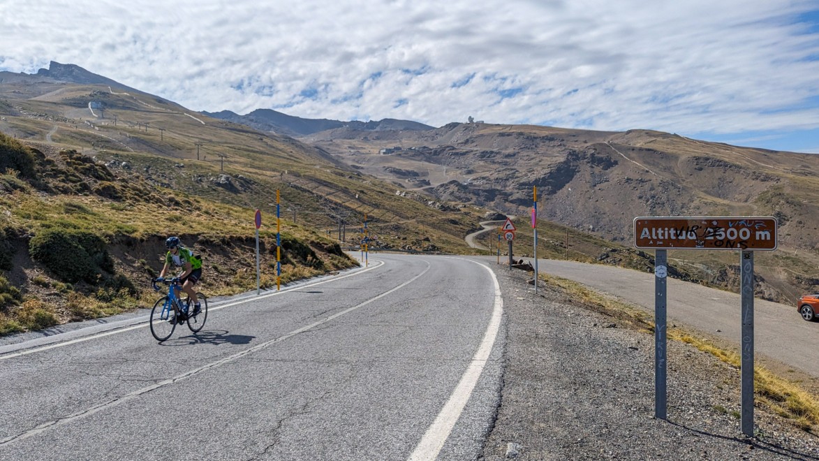 cycliste en pleine ascension du Pico Veleta, qui atteint 2500 m d'altitude comme indiqué sur le panneau