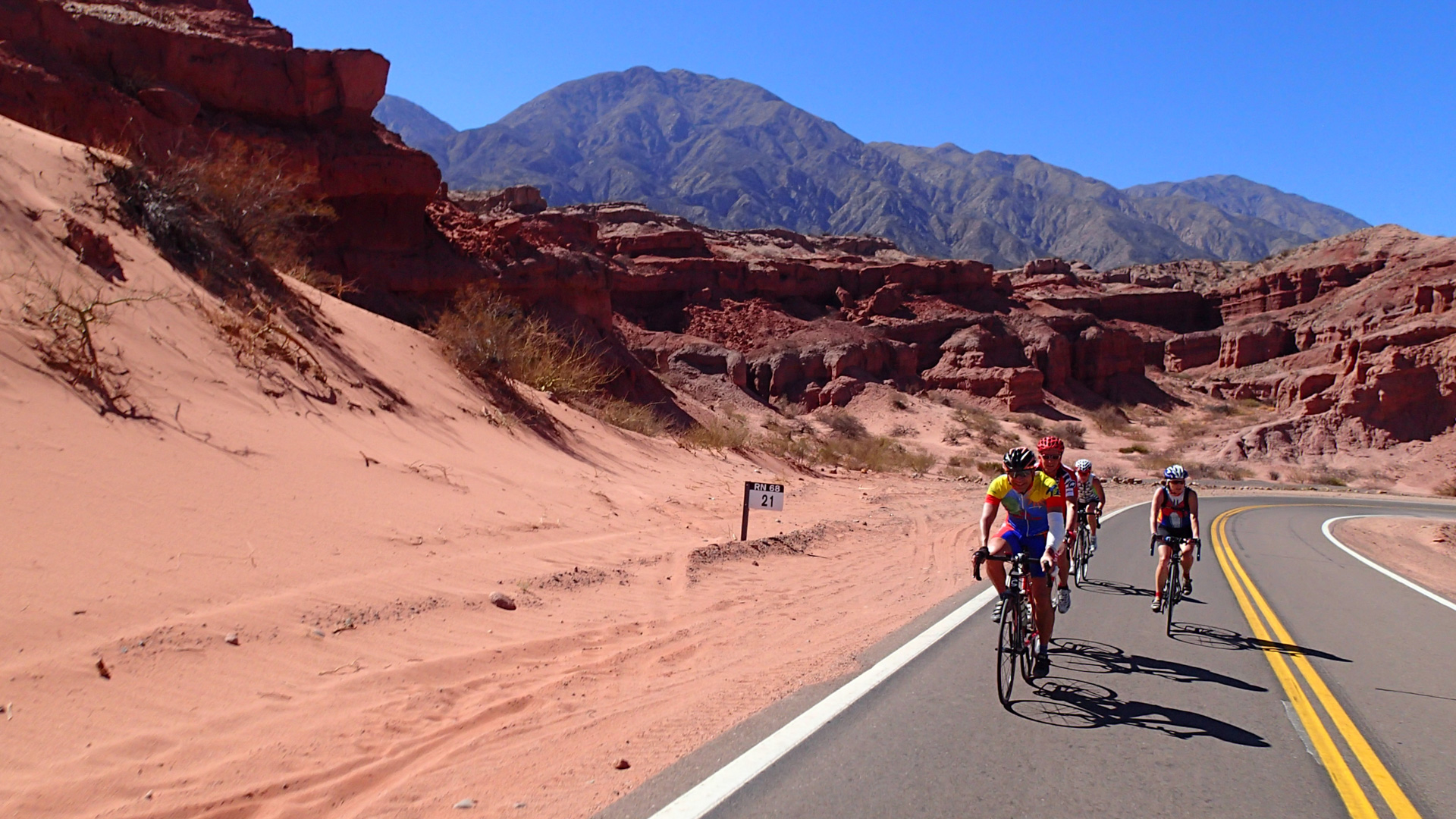 un groupe de cyclistes sur une route au milieu du canyon de la Quebrada