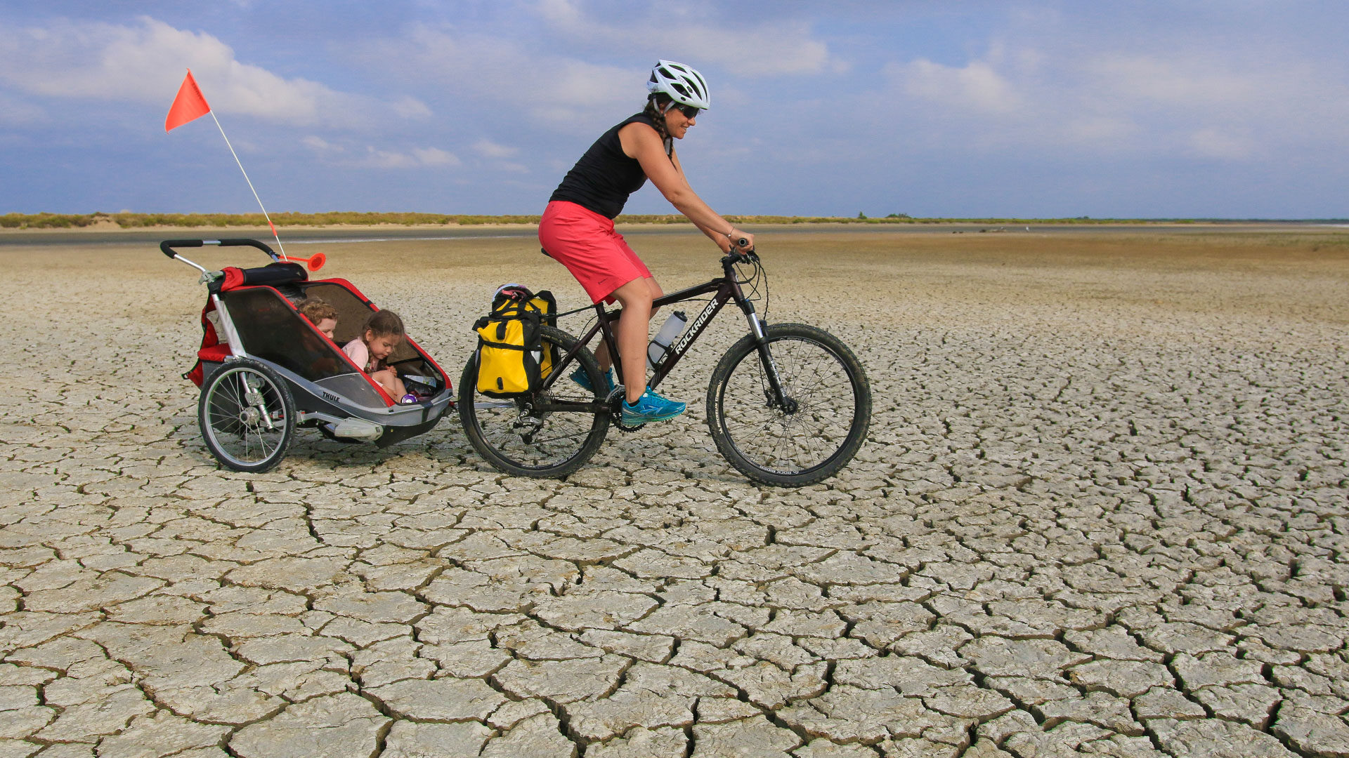 vélo et remorque enfant sur une terre craquelée en Camargue