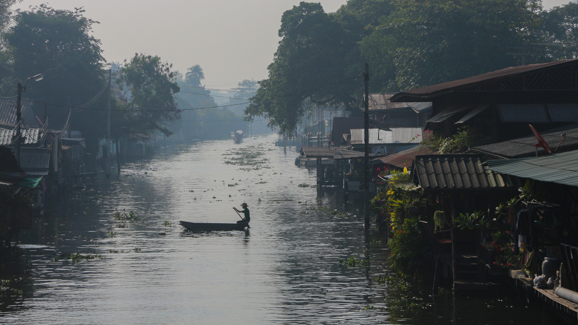 un homme sur une barque sur un canal de Thaïlande à proximité de Bangkok