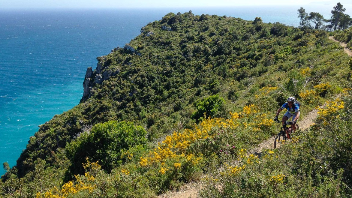 vététiste sur un petit single track en balcon sur la mer de Finale Ligure