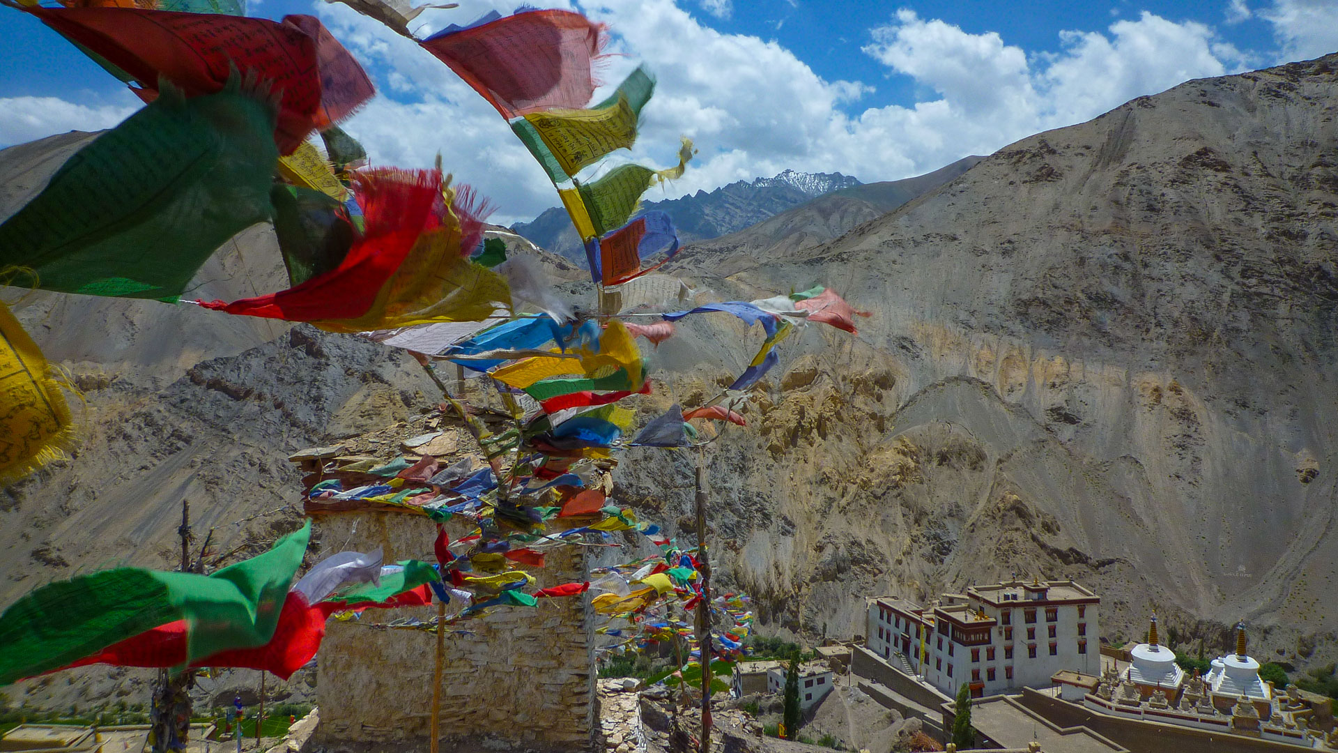 drapeaux bouddhistes avec la vue plongeante sur un temple, dans Ladakh