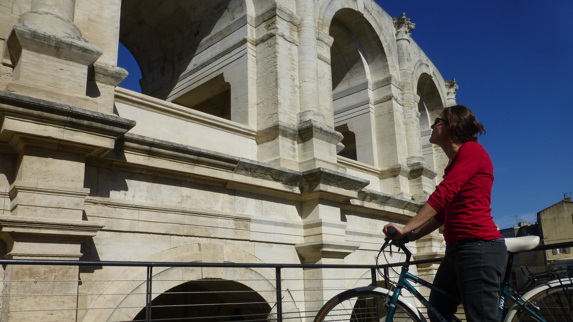 à vélo au pied des arènes à Arles