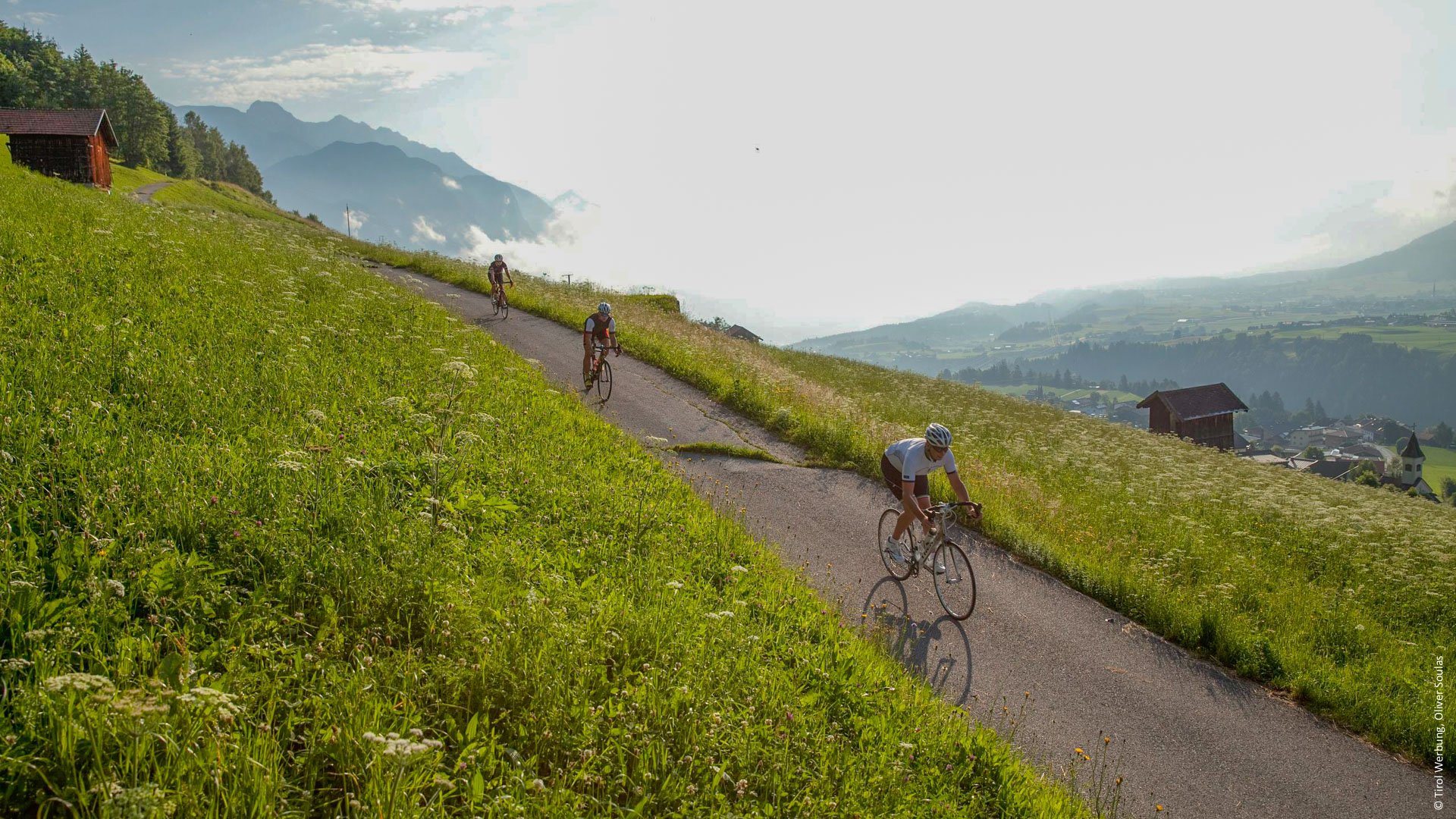 des cyclistes qui descendent une petite route goudronnée dans le Tyrol