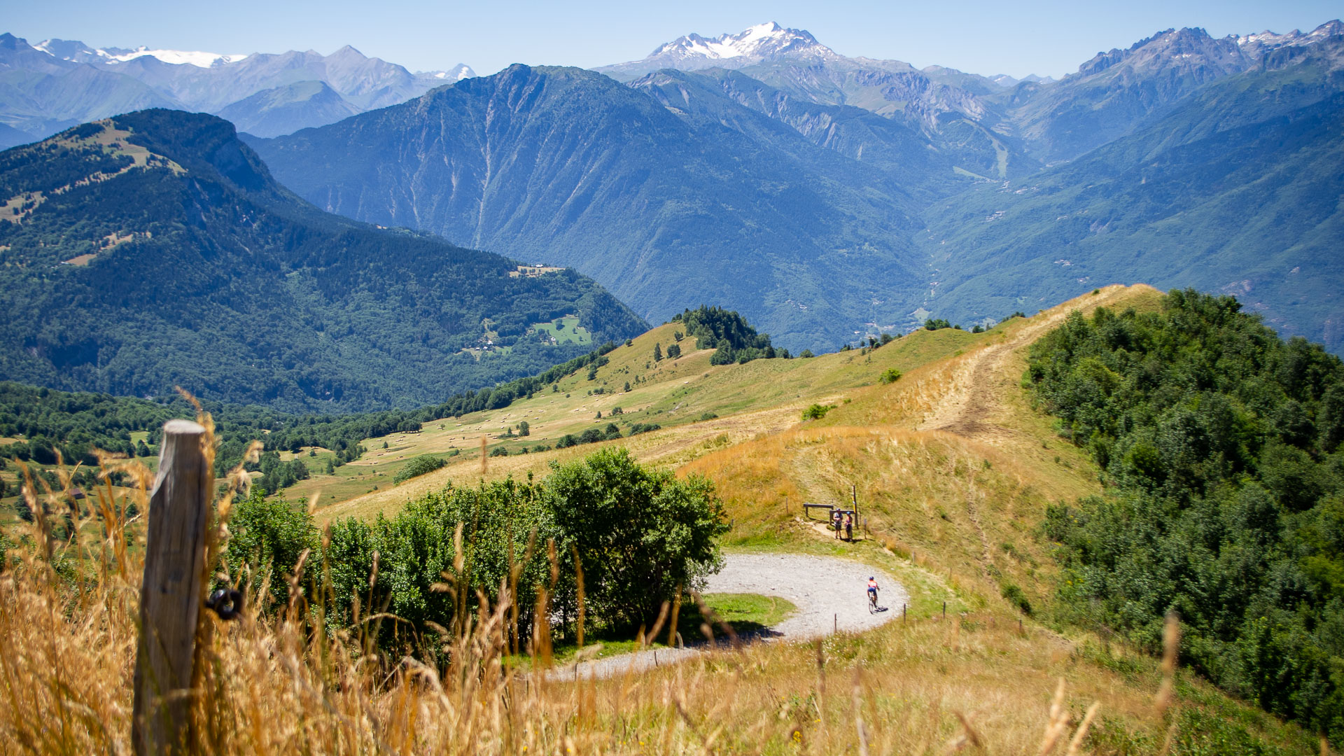 descente d'un cycliste en gravel avec la Chaîne des Alpes en fond.