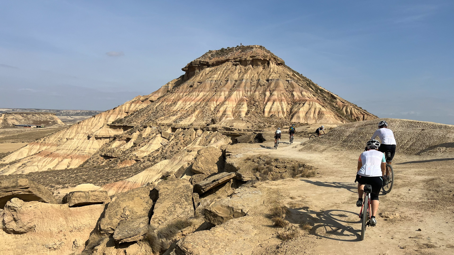 des cyclistes au milieu du désert des Bardenas, face au Cabezo de Las Cortinillas, point de vue sur le désert