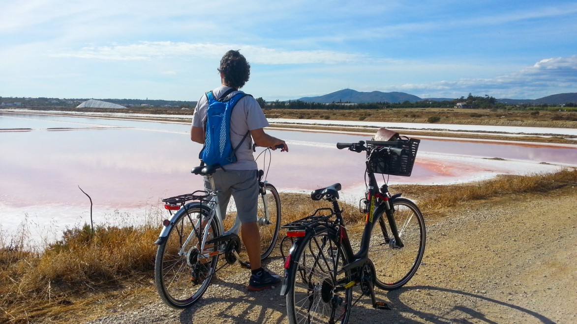 deux vélos et un cycliste devant un marais salant au Portugal