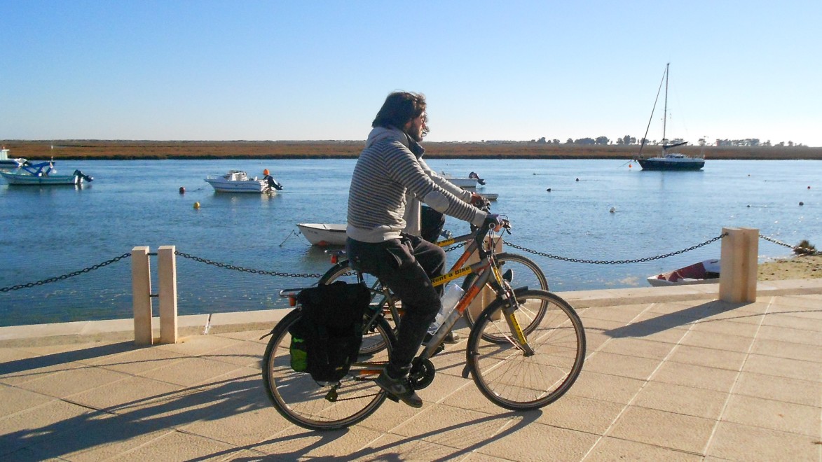 deux voyageurs à vélo longeant un port de plaisance en Algarve