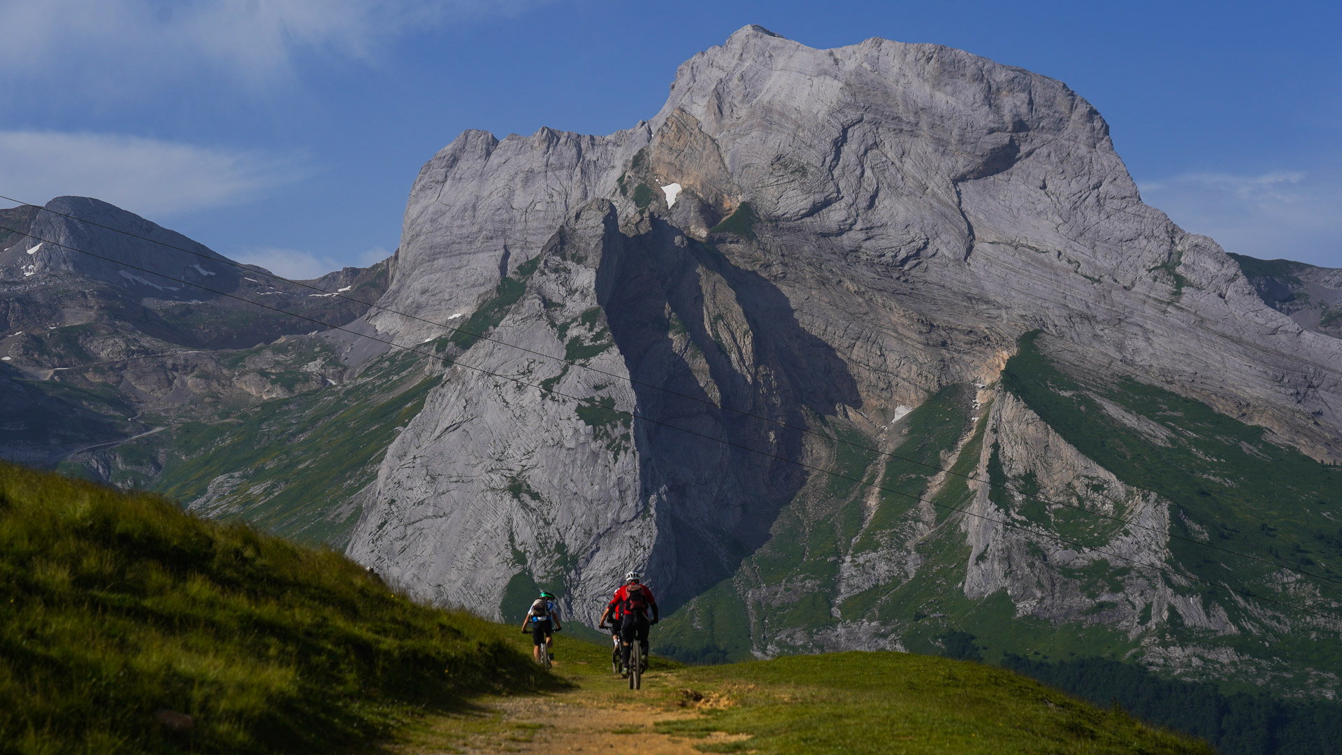 vététistes vue de dos devant un sommet minéral des pyrénées