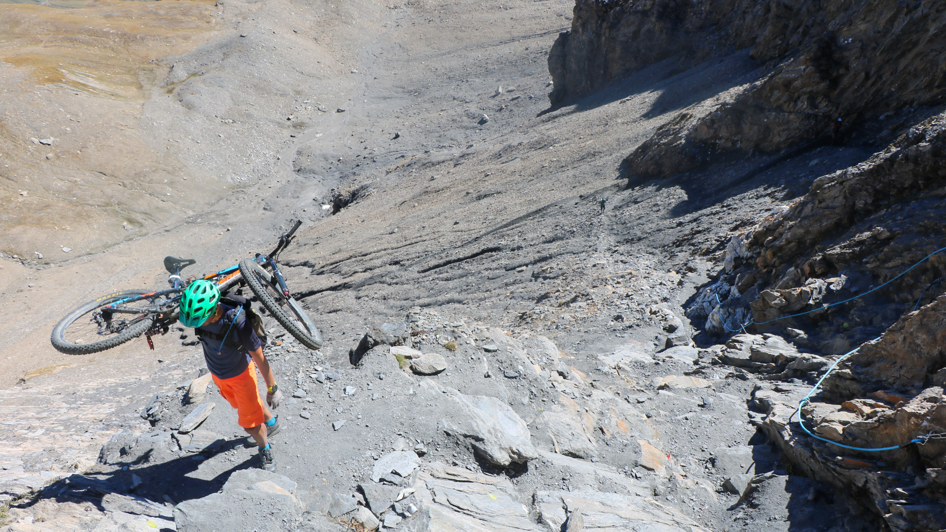 VTTiste porte son VTT lors de l'ascension d'un sommet