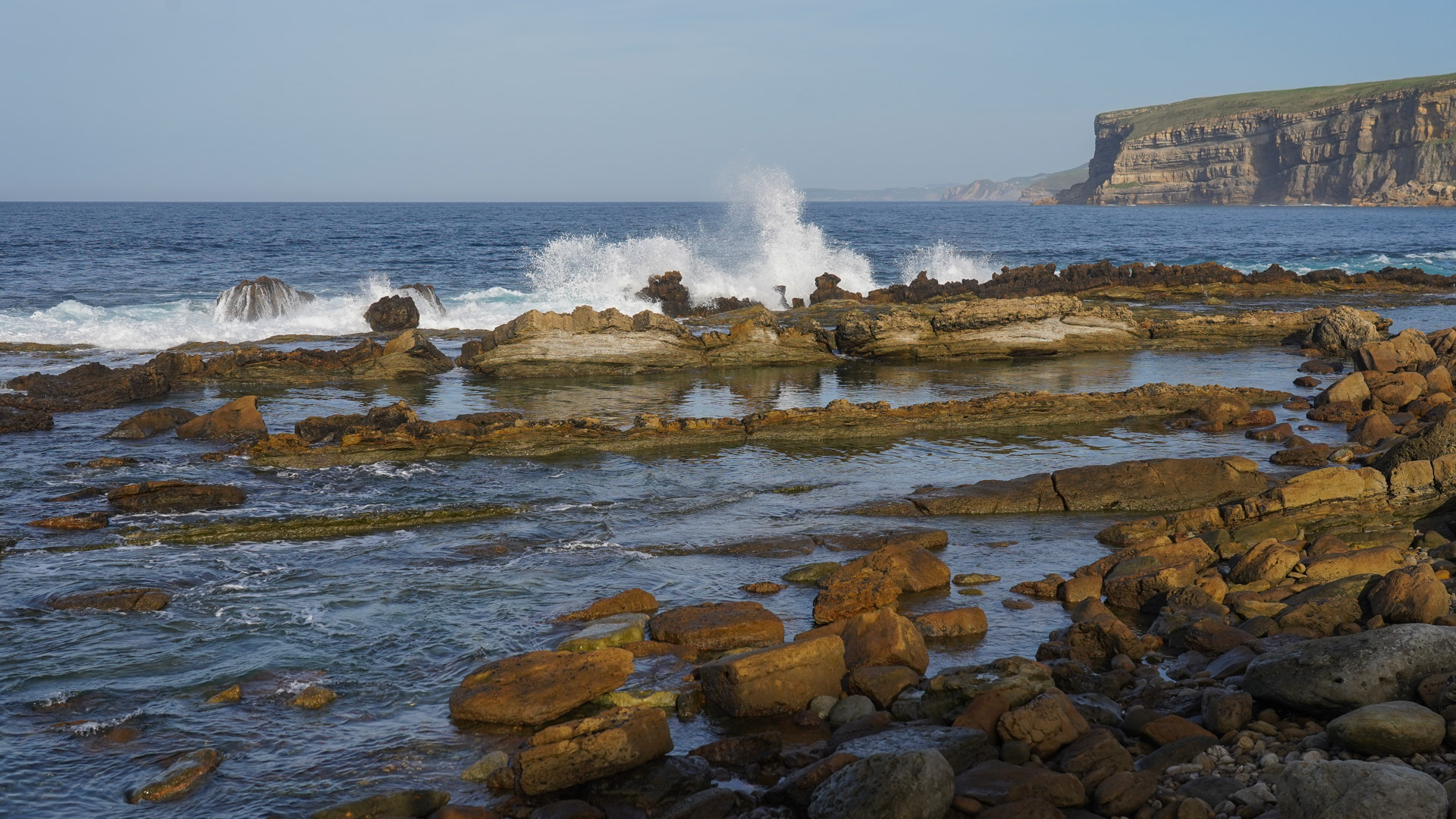 un rouleau s'écrase sur les rochers sculptés de la mer cantabrique