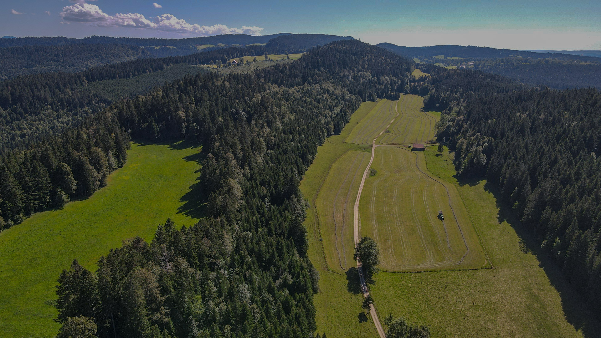 vue du ciel sur un petit chemin au milieu des grandes étendues de l'espace montagneux des Hautes Combes du Jura