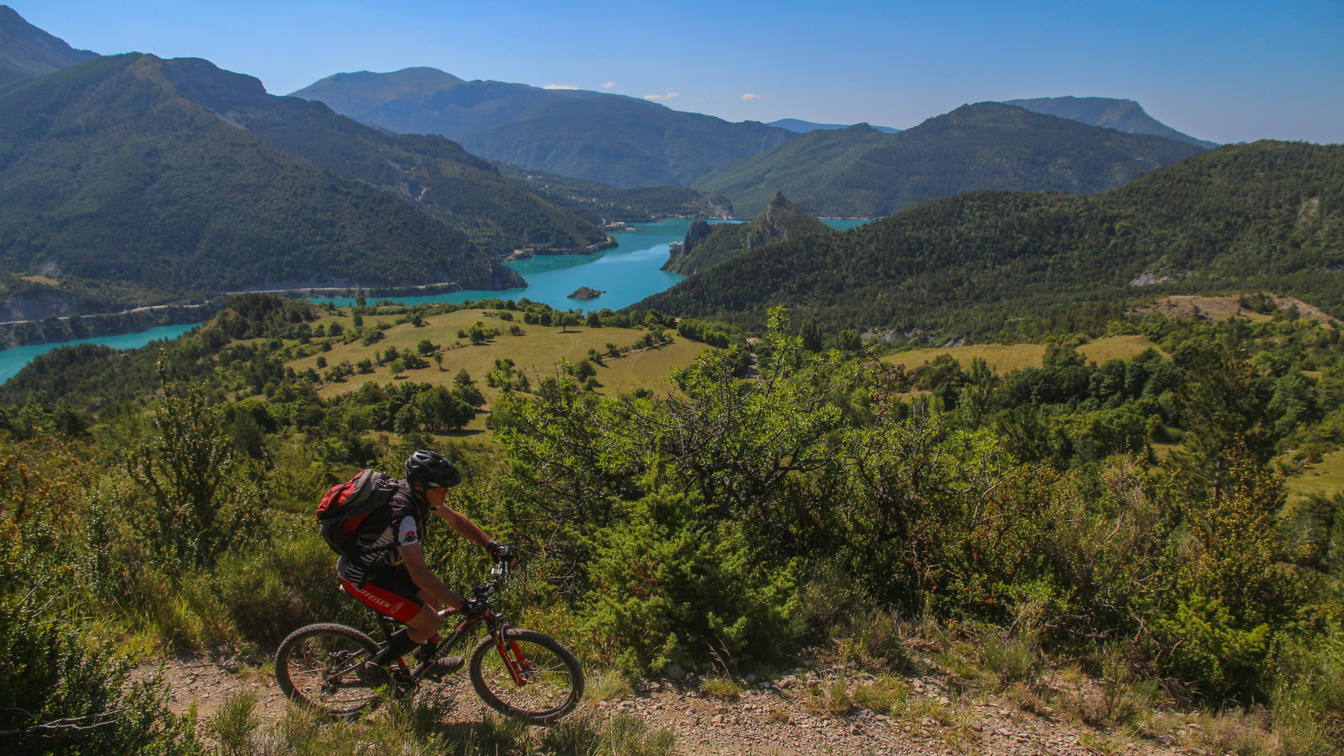 Vttiste soule sur un sentier, en arrière-plan le Verdon