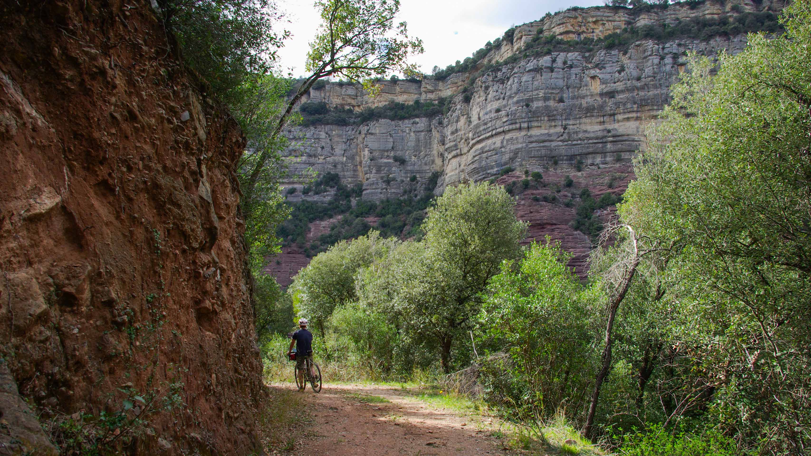 cycliste sur un petit chemin au milieu des falaises du massif des Guilleres
