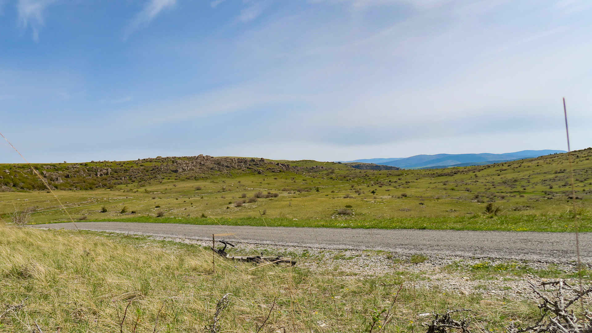 vélo gravel déposé au sol à coté d'une petite route sauvage dans les causses du massif central