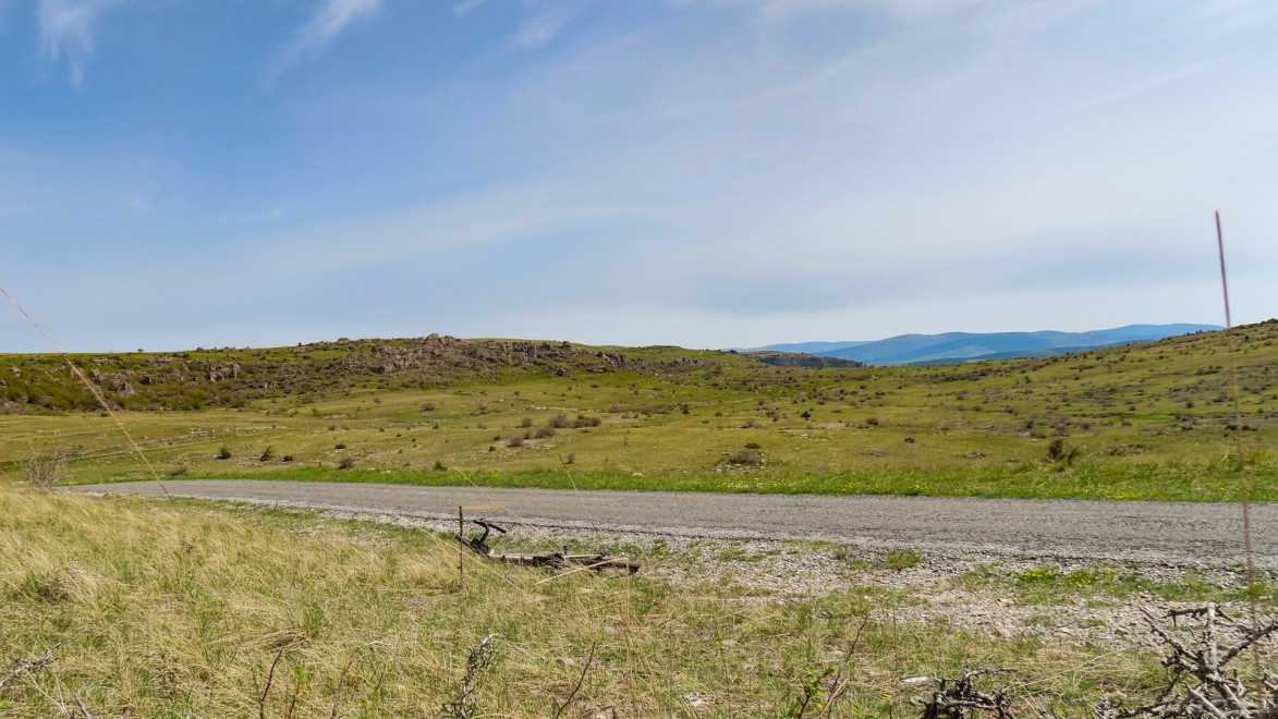vélo gravel déposé au sol à coté d'une petite route sauvage dans les causses du massif central