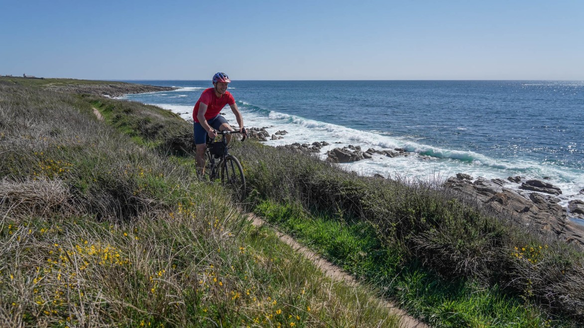 un gravel roule sur un single track au bord de l'océan en Bretagne