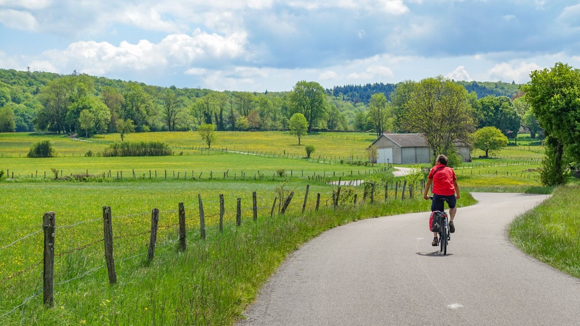 homme à vélo sur une petite route campagnarde du Jura