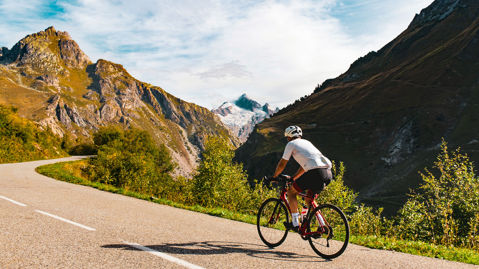 cycliste fait l'ascension d'un col avec vue sur le massif du Mont Blanc