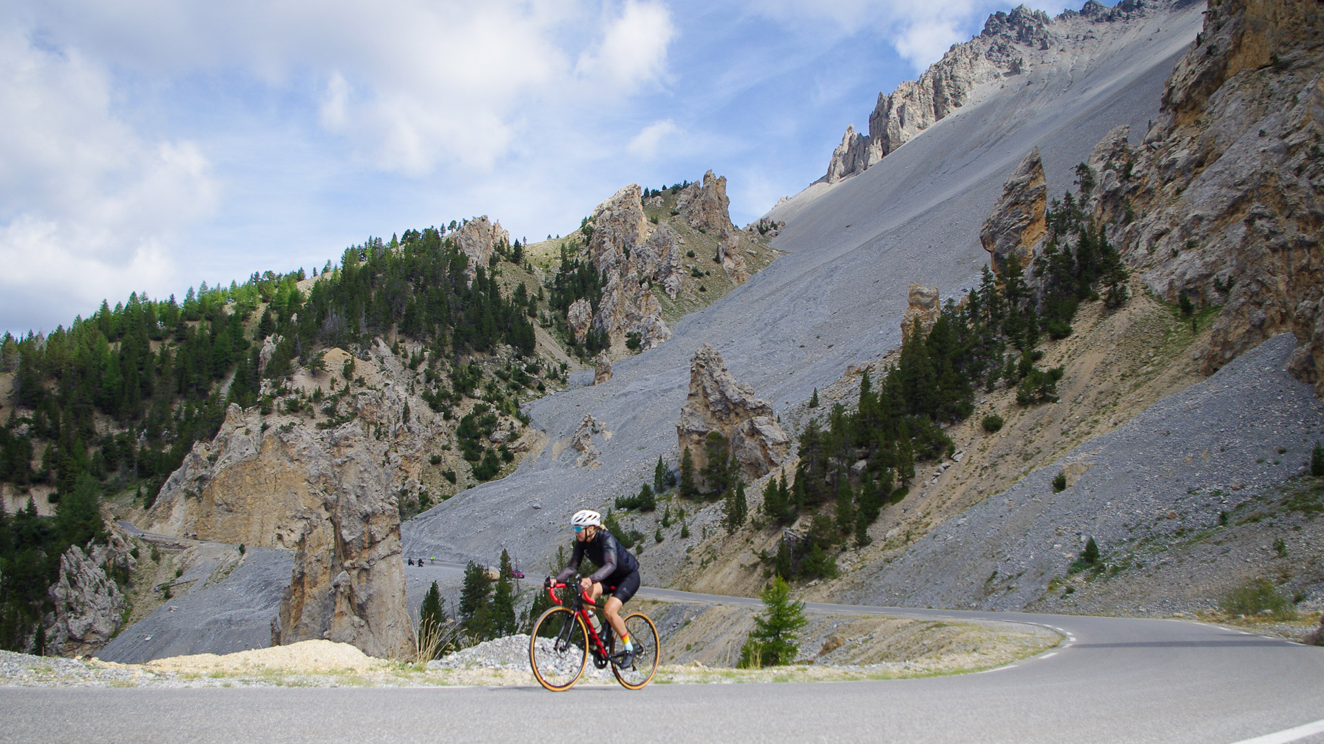 cycliste à vélo de route fait l'ascension du col de l'Izoard dans le Queyras, ambiance lunaire de la Casse Déserte