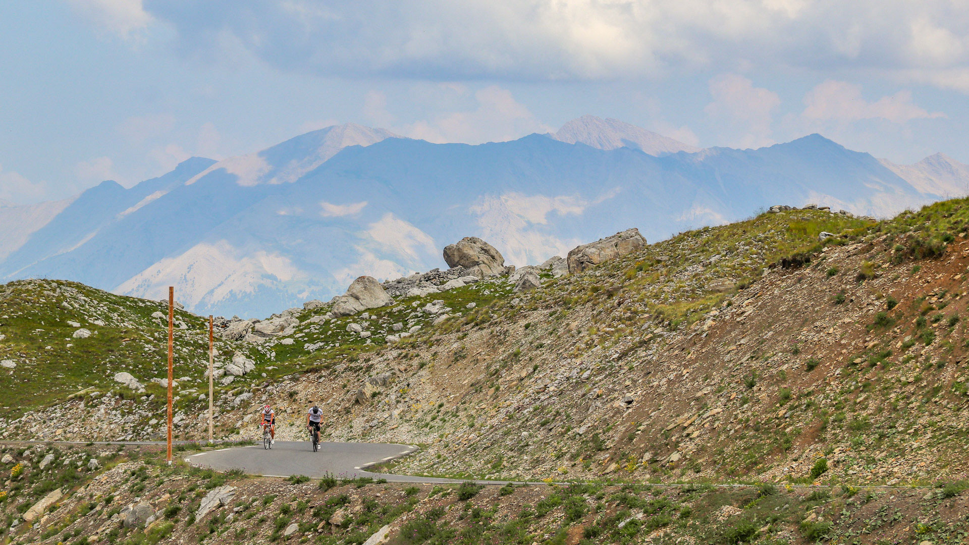deux cycliste grimpent le col de la Bonette, le paysage est minéral