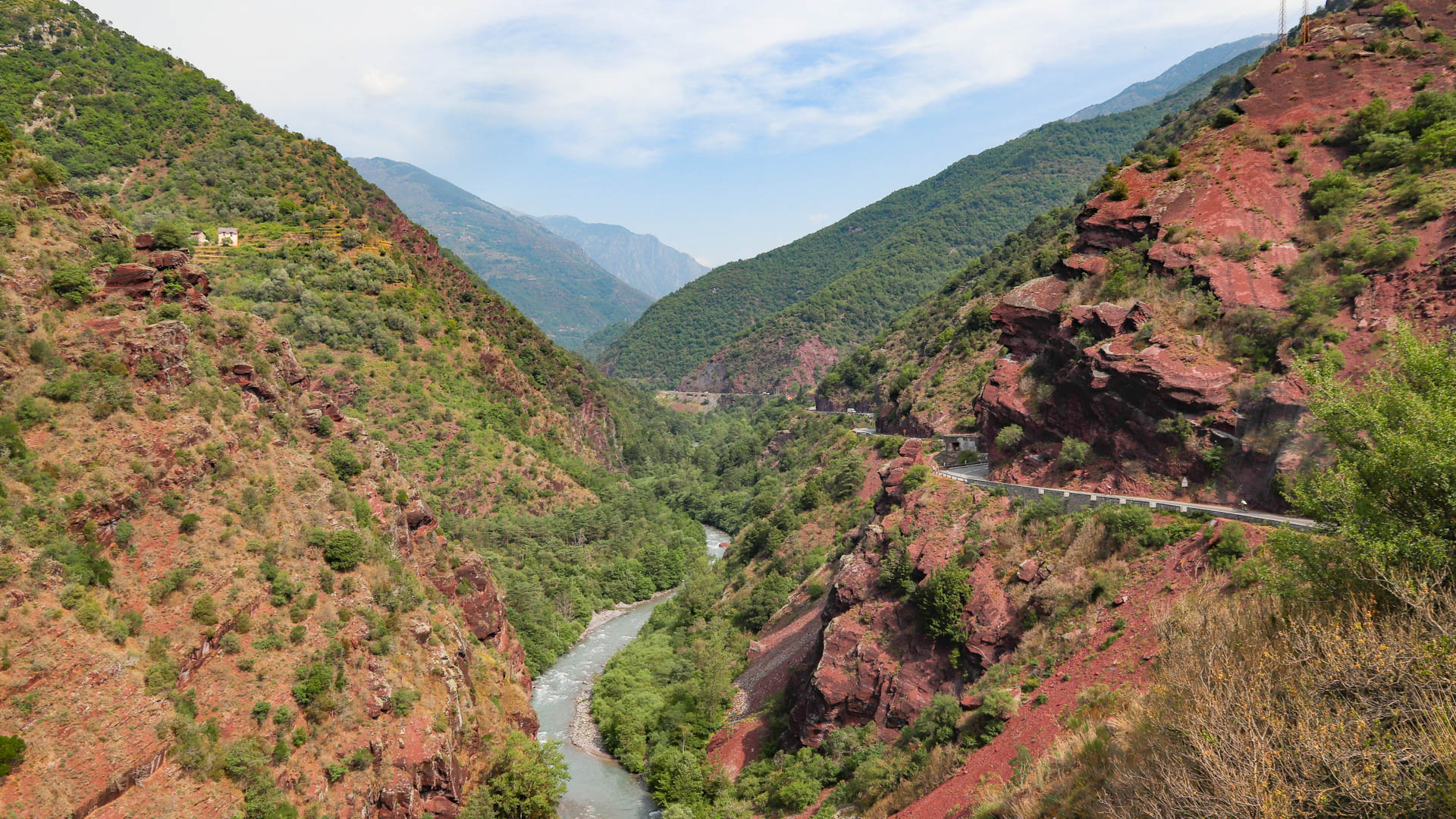 Deux cyclistes dans les gorges du Cians et de Daluis, la roche est ocre rouge